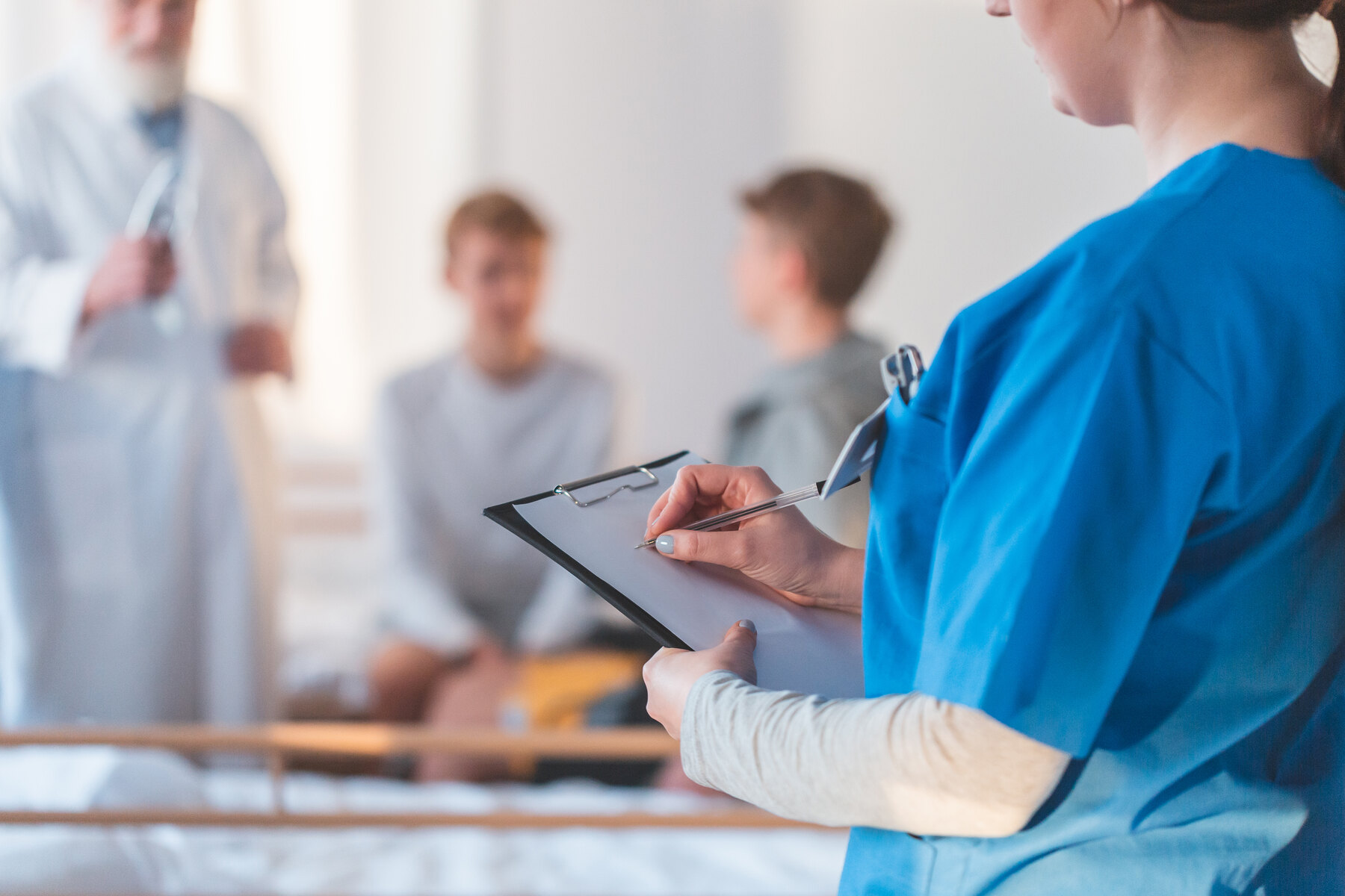 Specialist medical notând informații în timpul unei vizite